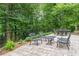 This beautiful patio features chairs and a table, overlooking a scenic tree filled area, perfect for entertaining at 8470 Lazy Oaks Ct, Atlanta, GA 30350