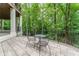 This beautiful patio features chairs and a table, overlooking a scenic tree filled area, perfect for entertaining at 8470 Lazy Oaks Ct, Atlanta, GA 30350