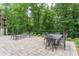 This beautiful patio features chairs and a table, overlooking a scenic tree filled area, perfect for entertaining at 8470 Lazy Oaks Ct, Atlanta, GA 30350