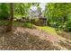 Backyard view of multi-story home with decks overlooking lush landscaping and stone patios at 8470 Lazy Oaks Ct, Atlanta, GA 30350