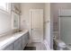 Bathroom featuring a marble countertop, gray cabinets, and tiled shower at 8470 Lazy Oaks Ct, Atlanta, GA 30350