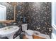 Powder room featuring floral wallpaper, pedestal sink, and decorative mirror at 8470 Lazy Oaks Ct, Atlanta, GA 30350