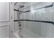 Bathroom with a white tiled tub-shower with glass doors and white subway tiles at 8470 Lazy Oaks Ct, Atlanta, GA 30350