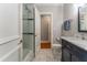 Bathroom with navy vanity and white subway tiled tub-shower with glass door at 8470 Lazy Oaks Ct, Atlanta, GA 30350