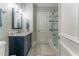 Bathroom with a modern vanity, marble floors, and a shower-tub with glass doors at 8470 Lazy Oaks Ct, Atlanta, GA 30350