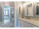Bathroom featuring a marble countertop vanity, framed mirror, and a glass-enclosed shower at 8470 Lazy Oaks Ct, Atlanta, GA 30350