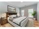 Cozy bedroom features a wooden headboard, light blue walls, and two bright windows at 8470 Lazy Oaks Ct, Atlanta, GA 30350