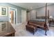 Spacious bedroom with four-poster bed, dresser, and a leather ottoman at 8470 Lazy Oaks Ct, Atlanta, GA 30350