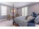 Comfortable bedroom with two chairs, a four-poster bed, and plenty of natural light from two windows at 8470 Lazy Oaks Ct, Atlanta, GA 30350