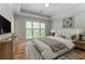 Serene bedroom featuring tray ceilings, a large window, and stylish decor with hardwood floors at 8470 Lazy Oaks Ct, Atlanta, GA 30350