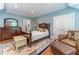 Primary bedroom with blue walls, hardwood floors, and classic furniture at 8470 Lazy Oaks Ct, Atlanta, GA 30350