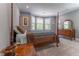 Bedroom featuring four-poster bed, neutral gray walls, and three windows at 8470 Lazy Oaks Ct, Atlanta, GA 30350