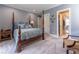Bedroom with four-poster bed, neutral gray walls, leading into the bathroom and walk-in closet at 8470 Lazy Oaks Ct, Atlanta, GA 30350