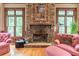 Stone fireplace with decorative mantel, flanked by windows, adding character to the room at 8470 Lazy Oaks Ct, Atlanta, GA 30350
