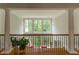 Bright foyer featuring large windows, hardwood floors, iron railing, and architectural columns at 8470 Lazy Oaks Ct, Atlanta, GA 30350