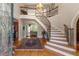 Grand foyer featuring a curved staircase with wrought iron railings and gleaming hardwood floors at 8470 Lazy Oaks Ct, Atlanta, GA 30350