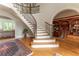 Elegant foyer with curved staircase, hardwood floors, arched entryways, and built-in bookshelves at 8470 Lazy Oaks Ct, Atlanta, GA 30350