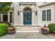 Elegant front entrance with blue double doors, detailed glass, and manicured landscaping at 8470 Lazy Oaks Ct, Atlanta, GA 30350
