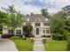 Stately home featuring blue shutters, manicured lawn, and a stone walkway leading to the entrance at 8470 Lazy Oaks Ct, Atlanta, GA 30350