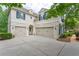 Side view of the home featuring a three car garage, stucco facade, and manicured landscaping at 8470 Lazy Oaks Ct, Atlanta, GA 30350