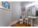 Well-lit half bathroom with pedestal sink, framed mirror, and hardwood floors at 8470 Lazy Oaks Ct, Atlanta, GA 30350