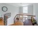 Upstairs hallway features hardwood floors, decorative railing, and elegant chandelier at 8470 Lazy Oaks Ct, Atlanta, GA 30350