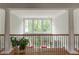 Hallway with white columns, hardwood floors, and views of the landscaped yard at 8470 Lazy Oaks Ct, Atlanta, GA 30350