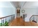 Upstairs hallway with hardwood floors, white walls, decorative columns, and wrought iron railing at 8470 Lazy Oaks Ct, Atlanta, GA 30350