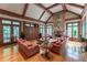 Spacious living room with stone fireplace, hardwood floors, beamed ceilings, and natural light at 8470 Lazy Oaks Ct, Atlanta, GA 30350