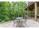 Stone patio featuring wrought iron table and chairs overlooks lush greenery at 8470 Lazy Oaks Ct, Atlanta, GA 30350