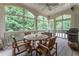 Charming screened porch with a dining table and wooded views, perfect for enjoying the outdoors at 8470 Lazy Oaks Ct, Atlanta, GA 30350
