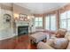 Inviting sitting room boasts a fireplace, built-in shelving, hardwood floors, and soft, natural light at 8470 Lazy Oaks Ct, Atlanta, GA 30350
