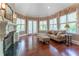 Cozy sitting room filled with natural light, featuring hardwood floors, fireplace, and elegant window treatments at 8470 Lazy Oaks Ct, Atlanta, GA 30350