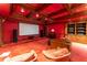 Luxurious theater room with ornate wood and red decor, large screen, and plush seating at 8470 Lazy Oaks Ct, Atlanta, GA 30350