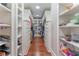 Spacious walk-in closet with custom shelving, drawers, and hardwood floors at 8470 Lazy Oaks Ct, Atlanta, GA 30350