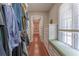 Walk-in closet featuring custom shelves, drawers, a bench seat, and hardwood floors at 8470 Lazy Oaks Ct, Atlanta, GA 30350