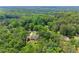 An aerial view displays a lovely yellow house nestled among mature trees with a sprawling green lawn at 1713 Dudley Dr, Woodstock, GA 30188