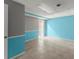 Large basement area featuring neutral tile floors, aqua accent walls, and doorframes with white trim at 1713 Dudley Dr, Woodstock, GA 30188