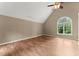 Vaulted ceiling bedroom with laminate flooring, ceiling fan, and arched window at 1713 Dudley Dr, Woodstock, GA 30188