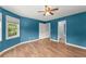 Well-lit bedroom with hard wood floors, a ceiling fan, and windows with backyard views at 1713 Dudley Dr, Woodstock, GA 30188