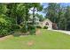 Charming yellow two-story home with a wraparound porch and lush green lawn at 1713 Dudley Dr, Woodstock, GA 30188