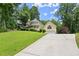 Charming yellow house with a wraparound porch, garage, and a long driveway at 1713 Dudley Dr, Woodstock, GA 30188