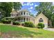 A charming yellow home with a wraparound porch and a well-manicured lawn at 1713 Dudley Dr, Woodstock, GA 30188