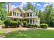 Charming yellow house with wraparound porch, black shutters, and landscaped front yard at 1713 Dudley Dr, Woodstock, GA 30188
