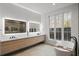 Bright bathroom featuring a soaking tub, double sink vanity, and large windows with wooded views at 185 Pebble Trl, Alpharetta, GA 30009