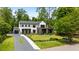 Beautiful two-story home boasts a manicured lawn, driveway, and lush greenery at 185 Pebble Trl, Alpharetta, GA 30009
