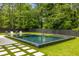 Beautiful backyard pool featuring sleek tile, a buddha statue, and a dark wood privacy fence at 185 Pebble Trl, Alpharetta, GA 30009