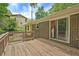 Wooden deck with sliding door access, brick exterior, and tranquil views of the backyard and sky at 3327 Spring Meadow Ct, Tucker, GA 30084