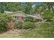Traditional brick home featuring a covered parking area, lush greenery, and well-manicured lawn at 3327 Spring Meadow Ct, Tucker, GA 30084