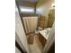 Compact bathroom featuring wood cabinetry, shower with curtain, and neutral tile at 384 Daniel Mill Xing, Villa Rica, GA 30180